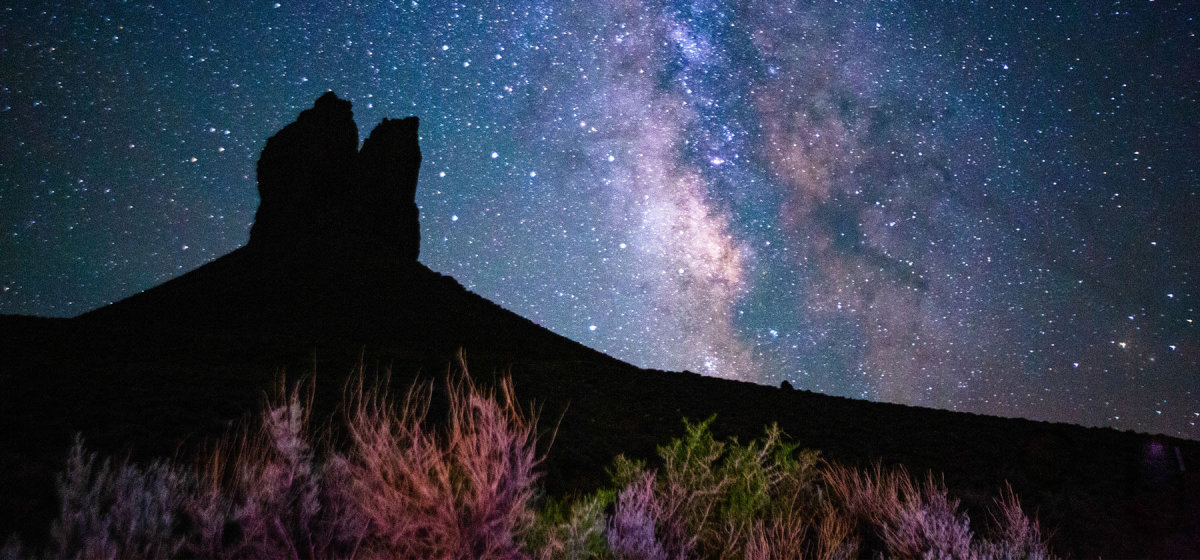 Boars Tusk rock formation silhouetted against a starry night sky in Sweetwater County, Wyoming.