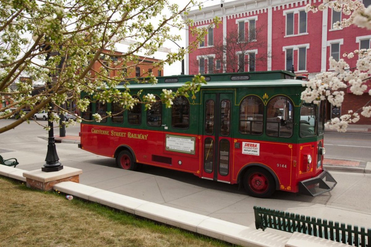 The Cheyenne Street Railway Trolley in front of a row of colorful historic buildings.