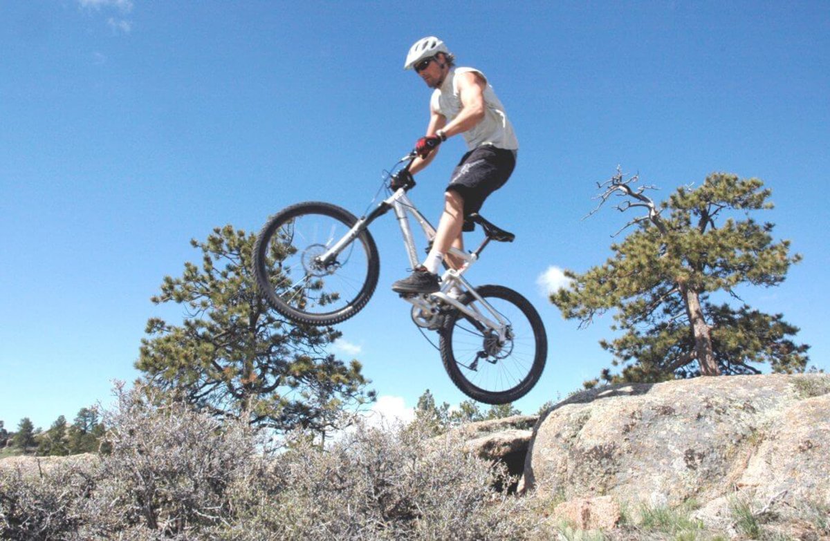 A biker wearing a white helmet takes his mountain bike vaulting in the air as he experiences one of the rugged trails in Curt Gowdy State Park in Laramie County, Wyoming.