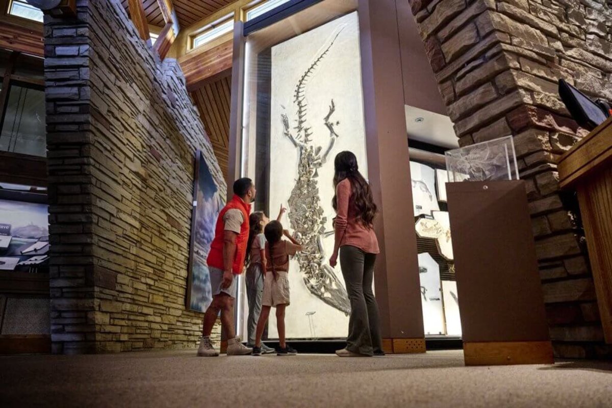 A family looks up at the Fossil Butte National Monument, as a young girl points in amazement at the fossil exhibit before them.