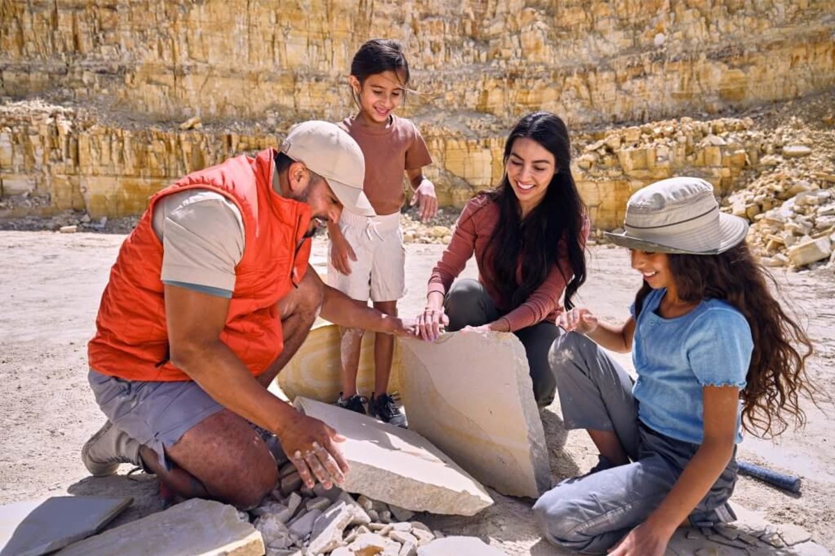 A family smiles as they dig through fossils together in Wyoming.