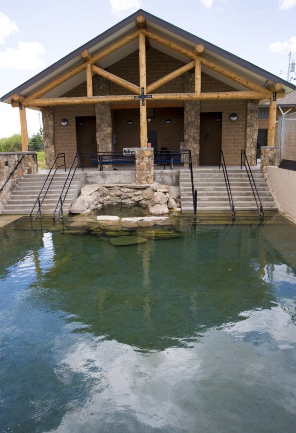 A natural hot spring pool in front of a building at the entrance of Hobo Pool.