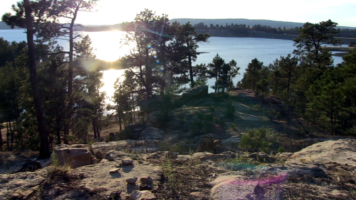 Keyhole Reservoir sits in the distance beyond the rocky shore.