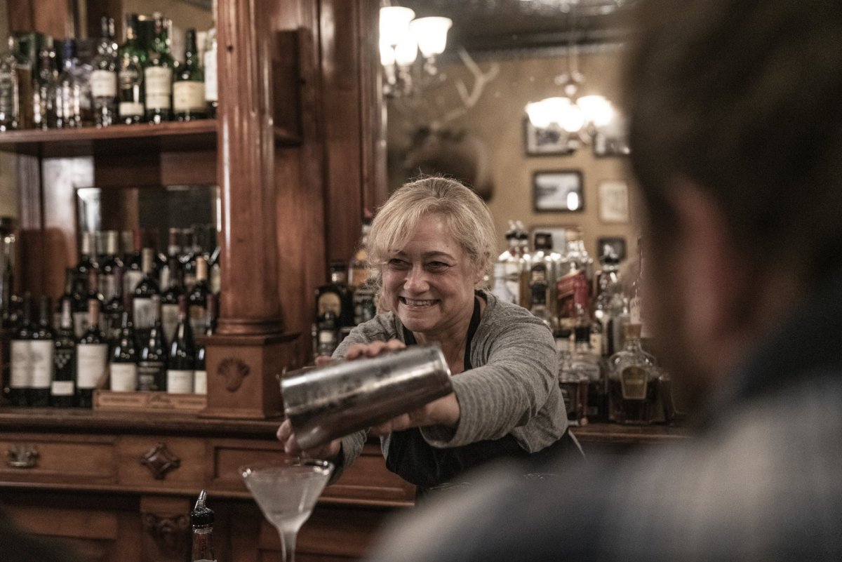 Woman serving a martini at the bar.