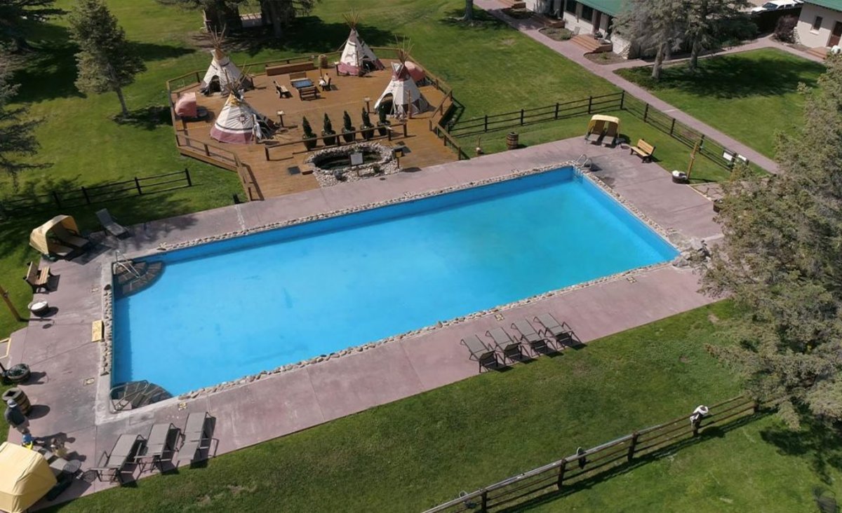 Four teepees covering hot pools on a patio alongside a mineral hot spring pool at Saratogo Hot Springs.