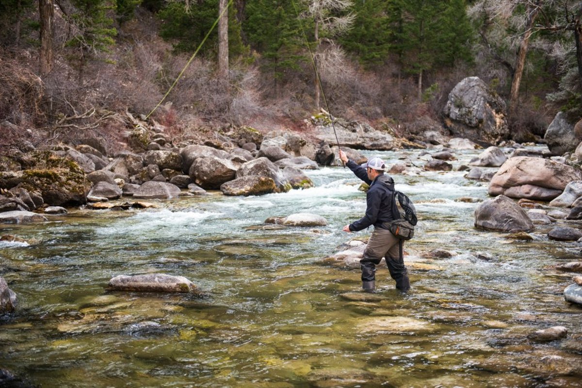 Fly fisherman in the middle of a river in the Bighorn Mountains in Wyoming