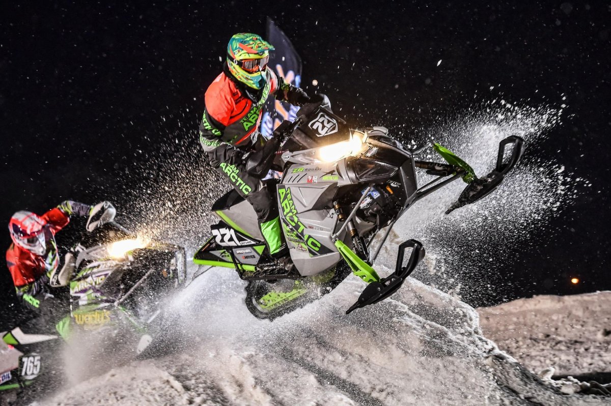 Snowmobilers racing on the trail.