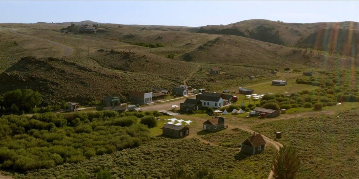 Sun rays stream through to the right overlooking the lush green landscape of South Pass City and all its historic structures.