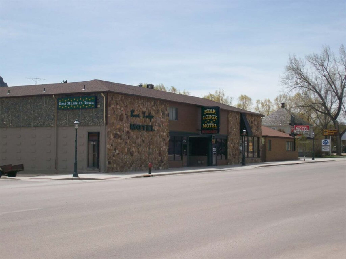 A street view of the Bear Lodge Motel in downtown Sundance, where a sign with bear tracks reads, "Best Maids in Town."