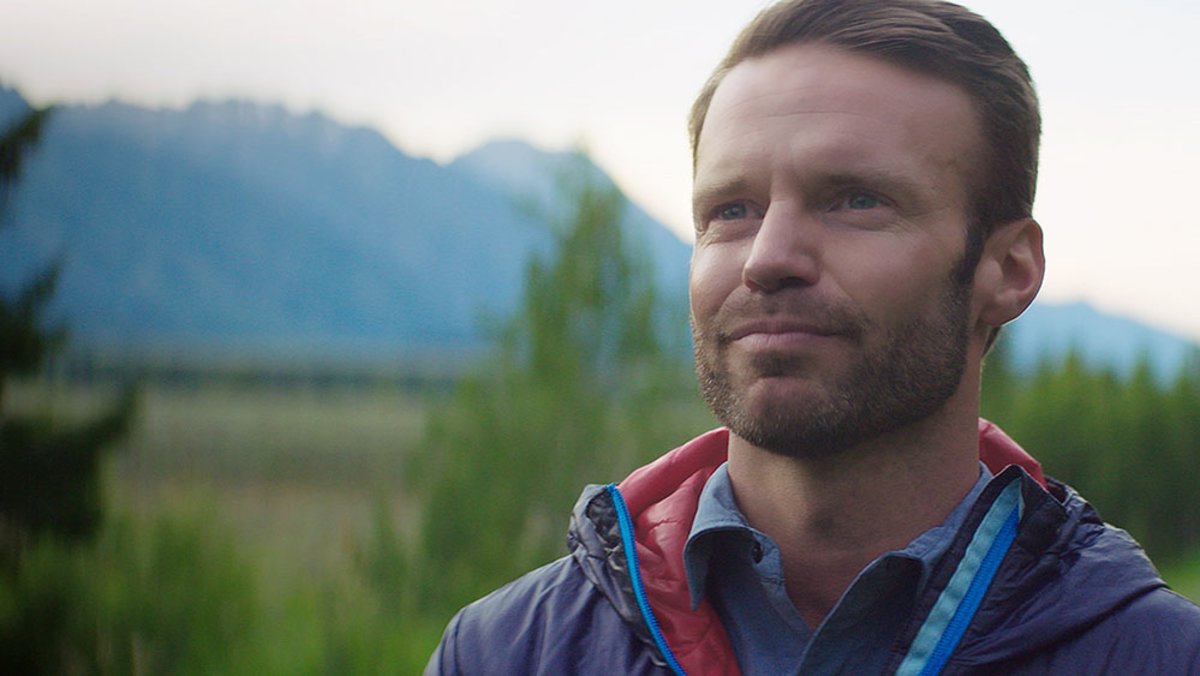 close photo of man with Tetons in background
