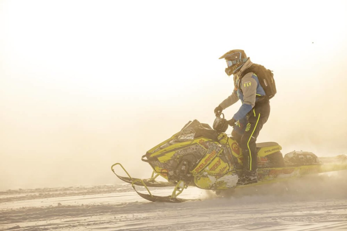 A man snowmobiling through Grand Teton National park 