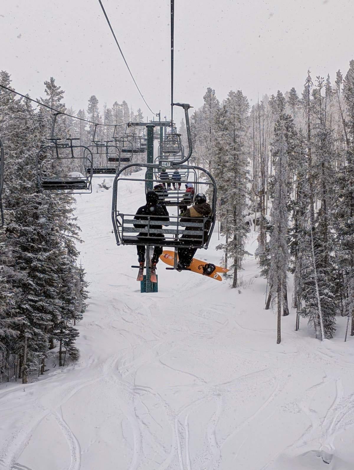 Skiers riding a ski lift at White Pine Resort.