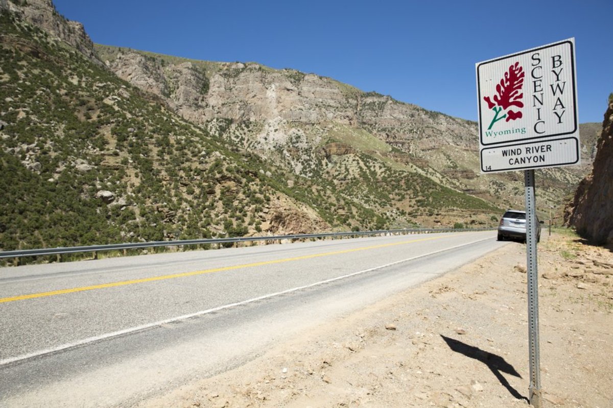Sign of the scenic byway Wind River Canyon with mountain range to the left