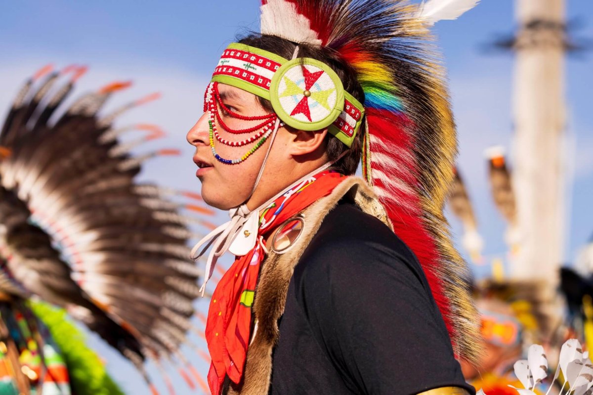 A close-up of a man wearing a headdress and traditional clothing at the Annual Eastern Shoshone Indian Days Powwow.