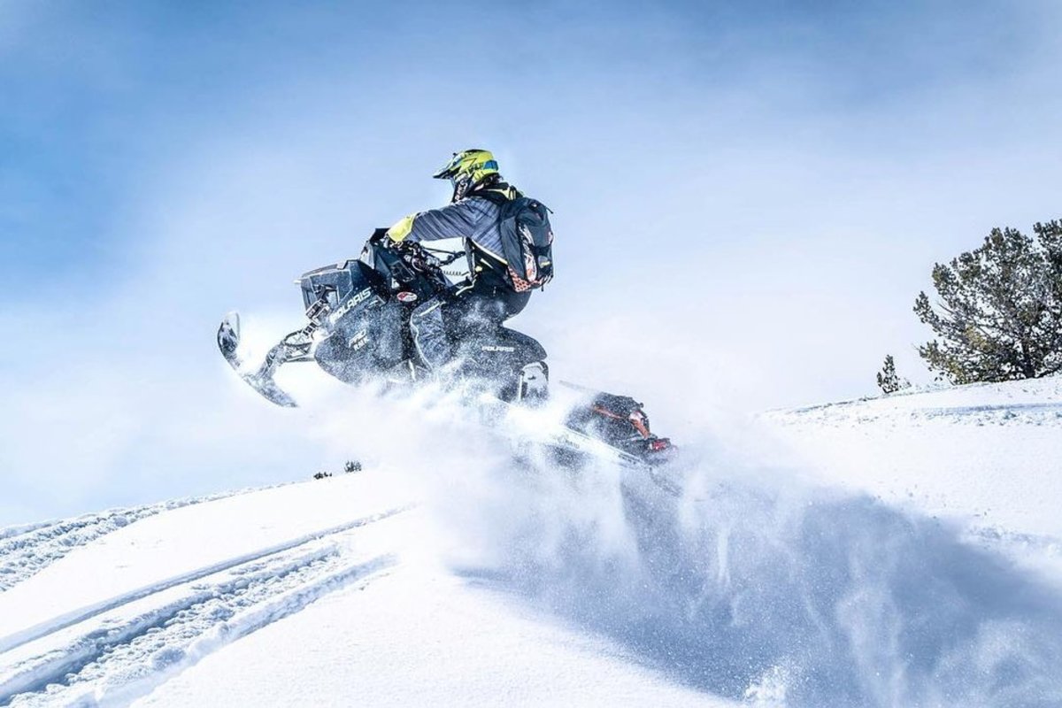snowmobiler riding through the snow.
