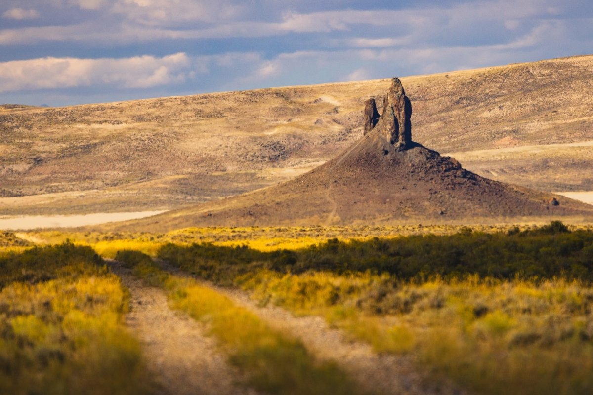 Boar's Tusk rising from the plains with the Red Desert in the background