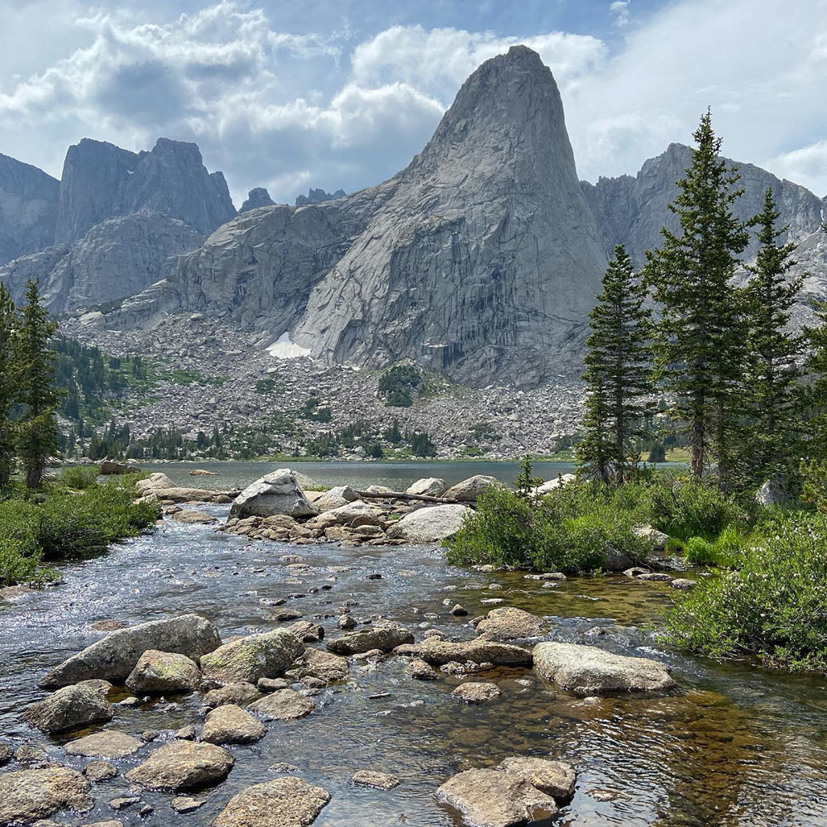 A river leads into the Backcountry Alpine Lake, another popular swimming spot in Wyoming.