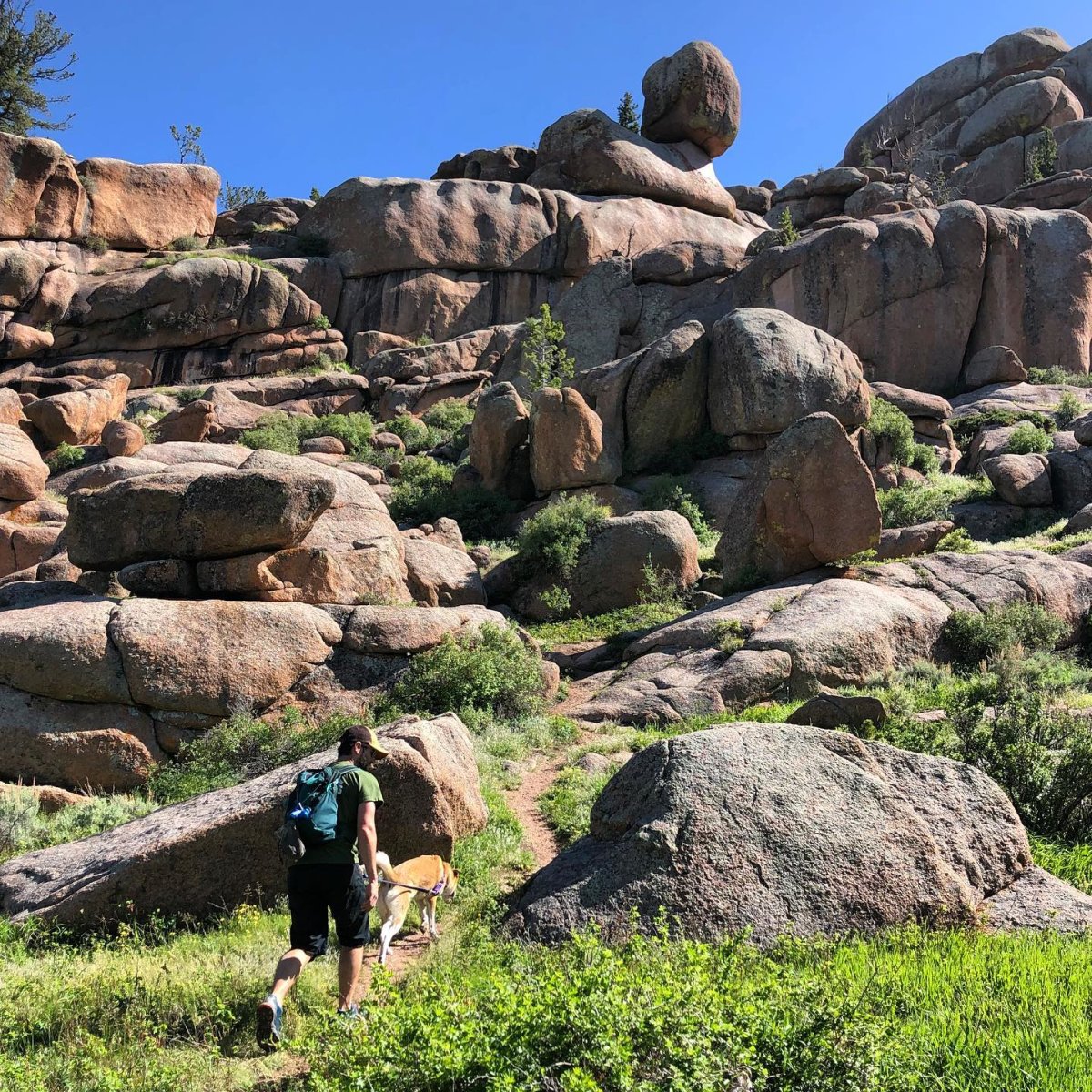 A man and his dog walking through the rock formations of Vedauwoo, a unique place to visit in Wyoming