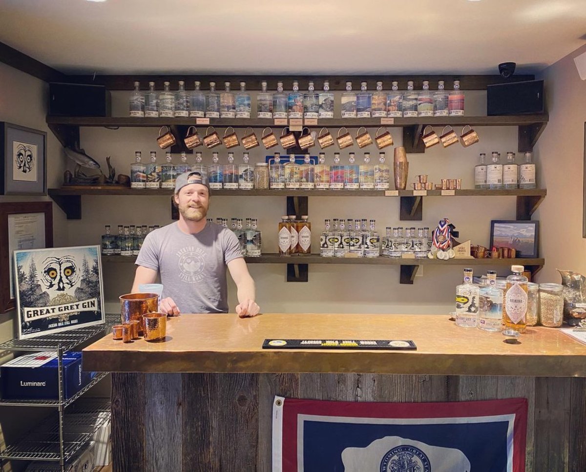 A bartender stands in front of a wall of craft whiskey and spirits brewed onsite at Jackson Hole Still Works in Jackson, Wyoming.