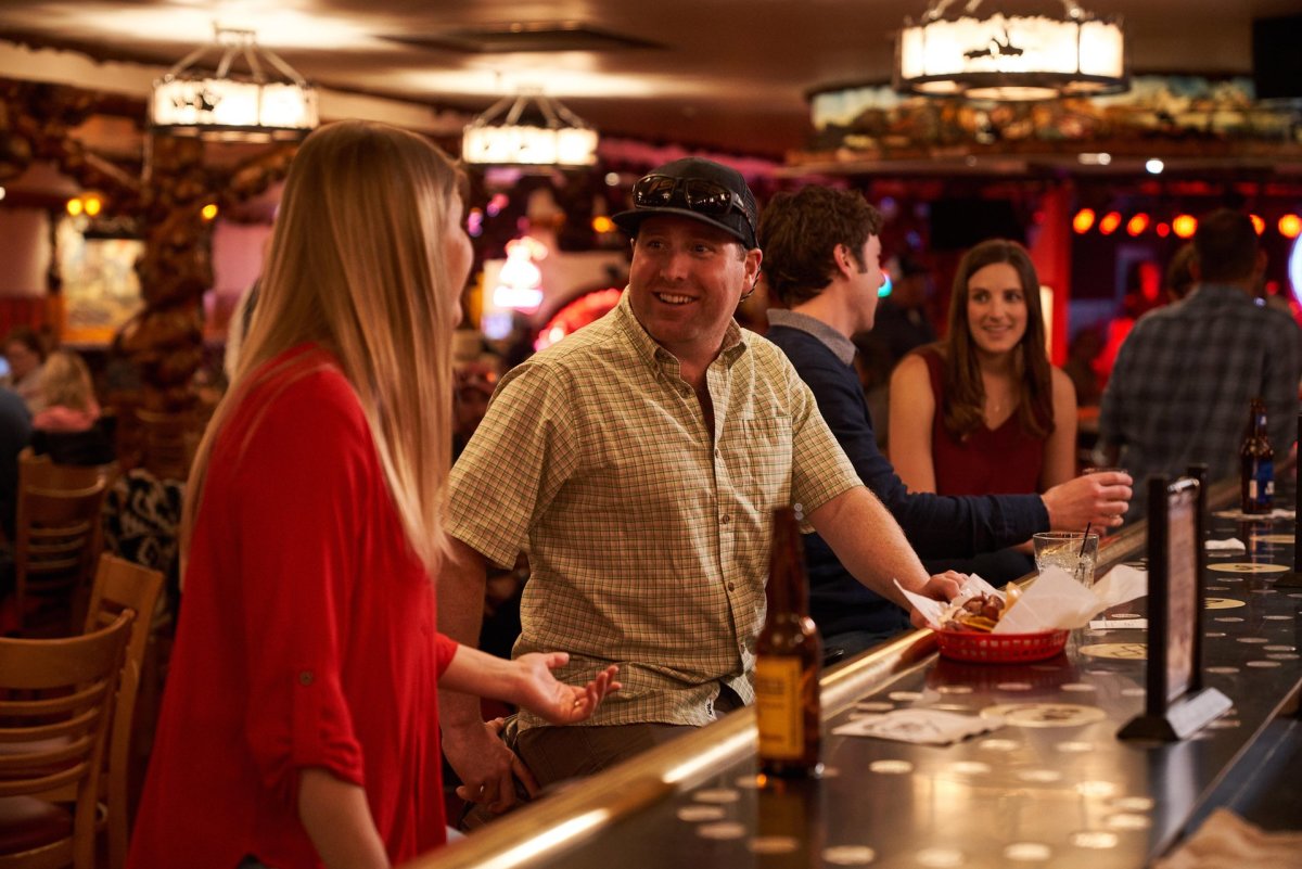 Couples talking and drinking at the bar.