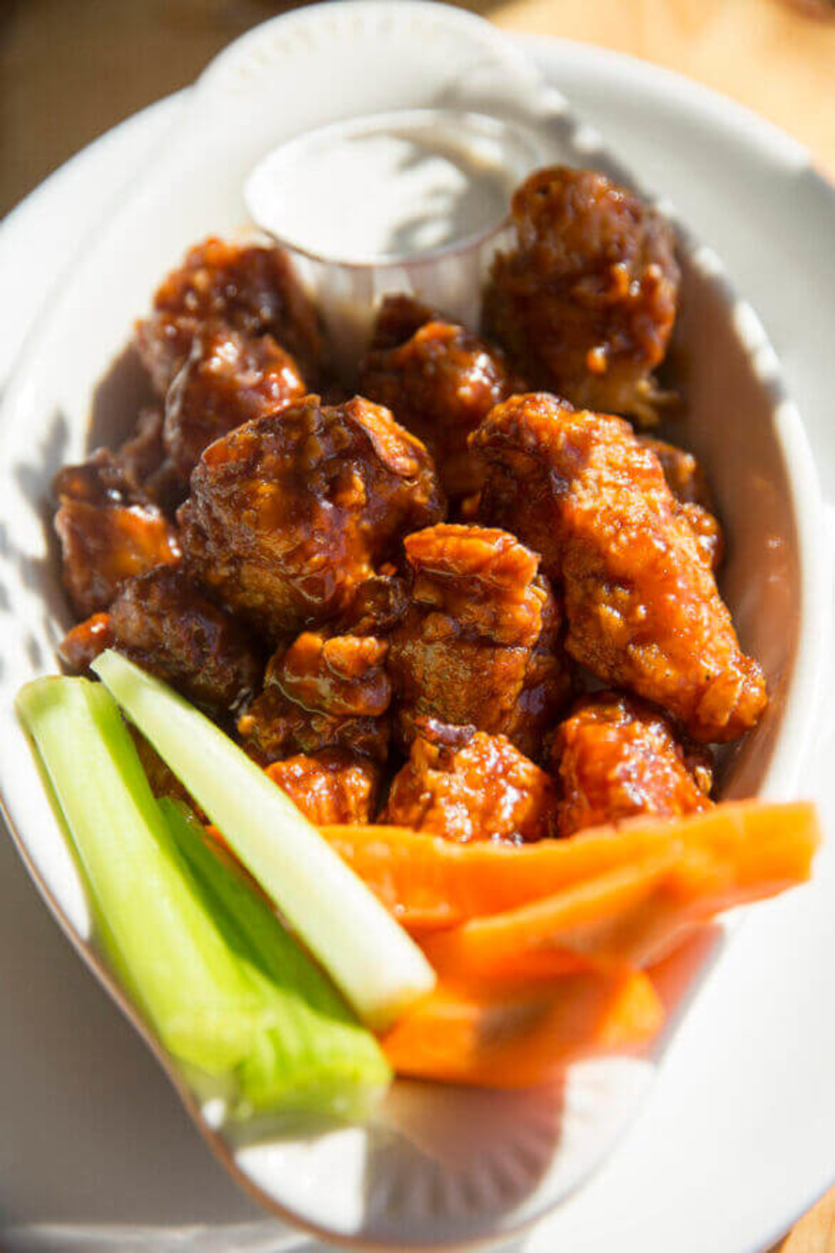 A dish of cauliflower wings, carrot sticks and celery sticks at Sweet Melissa Café.
