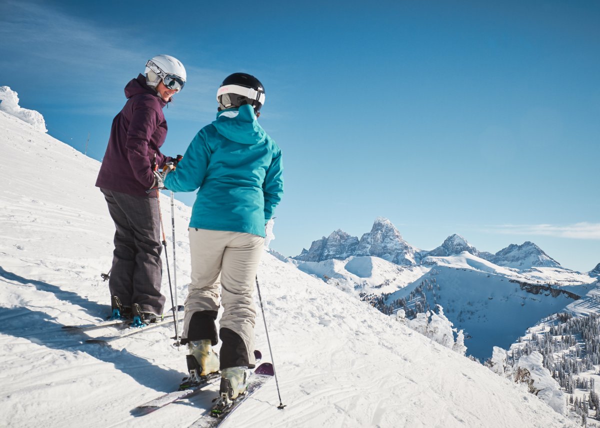 Two skiers talking at the top of the mountain in Grand Targhee Resort.