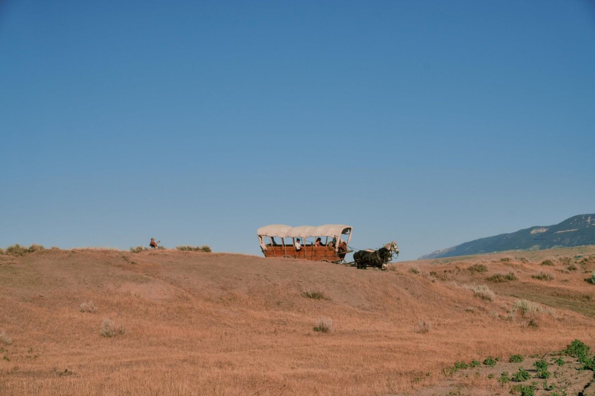 Covered wagon on a dry landscape, filled with hidden histories in Wyoming.