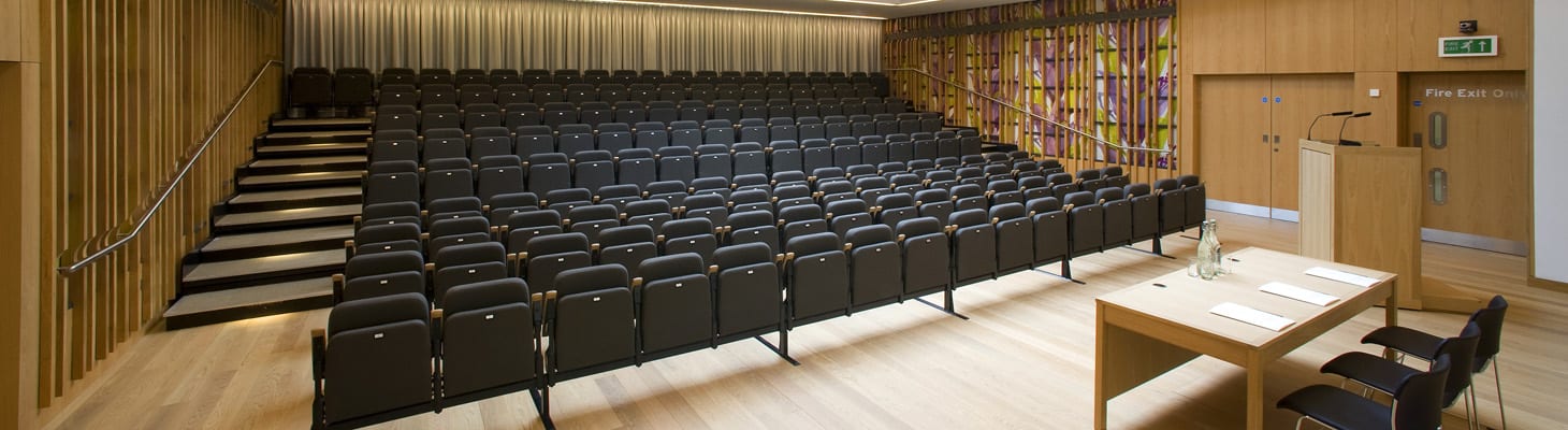 The auditorium provides tiered retractable seating for up to 154 delegates, fully equipped with customisable lighting and audio-visual facilities. The flexibility of the auditorium allows you to create a bespoke environment and range of seating options which can to be used for meetings, lectures, performances and receptions.
The open plan foyer creates an excellent space for guest registrations, exhibitions and refreshment breaks with the option of separating the foyer from the auditorium with a retractable wall. Direct access is also provided to the Dining Hall, Bar, and additional breakout rooms.