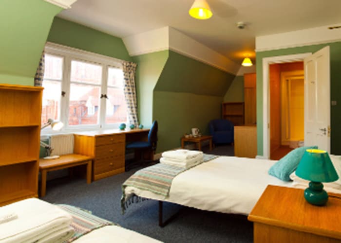 A twin en suite bedroom, with a large window, desk and chair. Ideal conference accommodation in Cambridge.