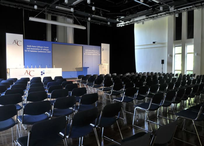 Modern 260 seater auditorium, with a hired staging set on the built in stage, rows of chairs, ideal as exhibition space with poster boards or a large conference room