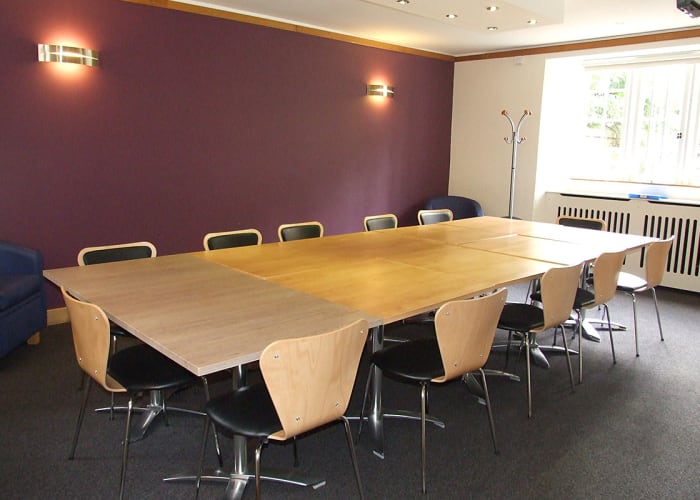 Chapel Court Room is a modern meeting space with a boardroom table to seat 12 delegates and a window overlooking the Chapel Court.