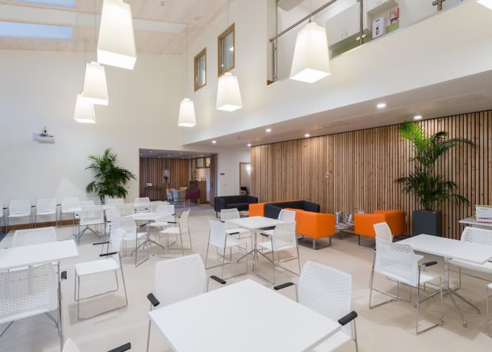 A bright, modern space set with chairs and tables available as a breakout space.