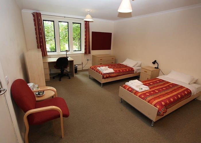 Ann's Court twin en suite bedroom, with two beds, armchair and workspace, a great option for conference accommodation.
