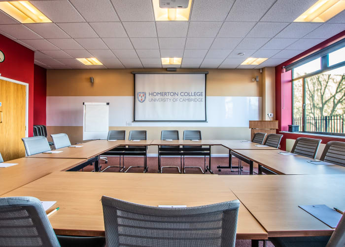 Bright room with large window on one side of the room, set hollow square boardroom style and fully equipped with AV equipment
