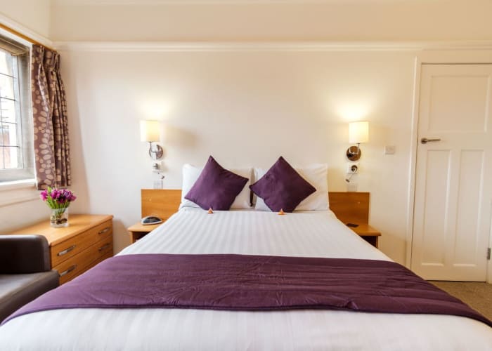 A comfortable double bed in a bedroom at Westminster College, Cambridge, an ideal option for conference bedrooms.