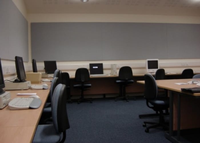 Number of desks around the edge of this modern room with a computer at each table. Ideal for training and IT events.