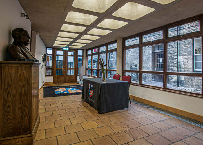The McCrum foyer, windows along two sides let in natural light, with a welcome desk making it the perfect location for conference registration.