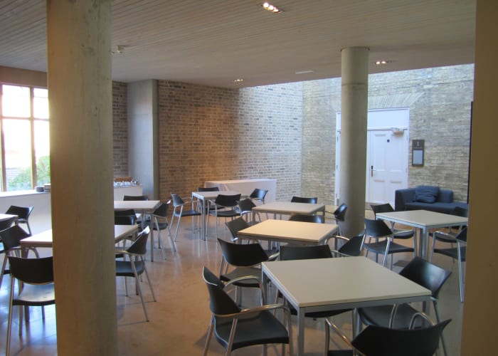 Cripps East room, with chairs and tables, an ideal event space for hire in Cambridge.