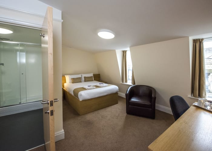 The double room includes a double sized bed, an arm chair, a work station with a refreshments section and en suite.