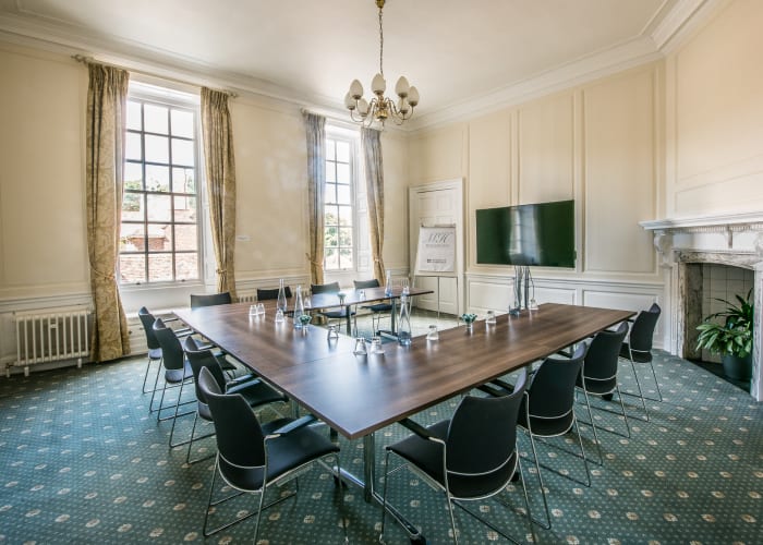 West room - U-Shaped layout seated for 12 delegates, with a screen at the front centre and a fireplace off to the right.
