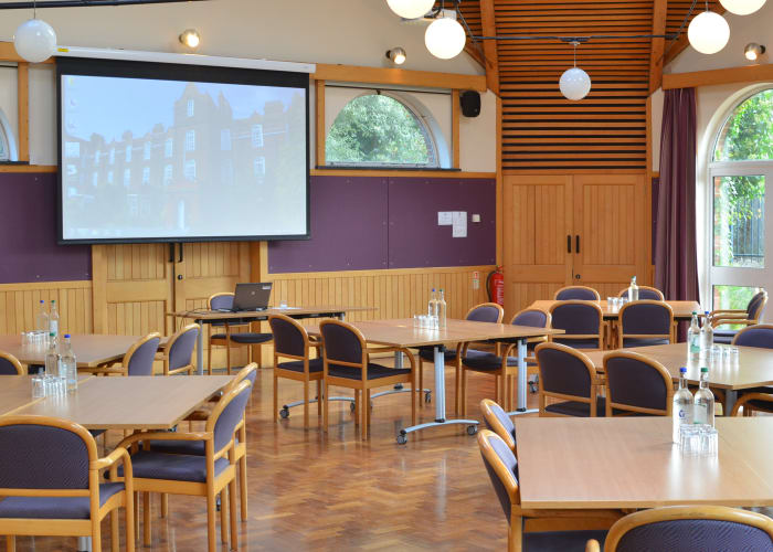 A bright and spacious meeting room set cabaret style with a screen at the front, ideal for team meetings and workshops.