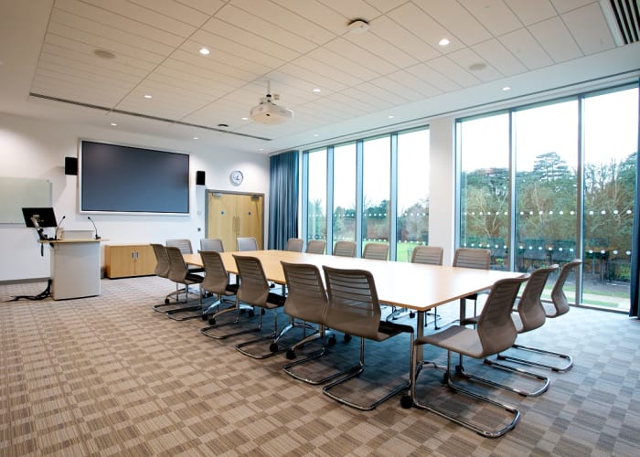 Queen Edith's meeting room set up boardroom style, a large bright and airy meeting room fully equipped with AV equipment.