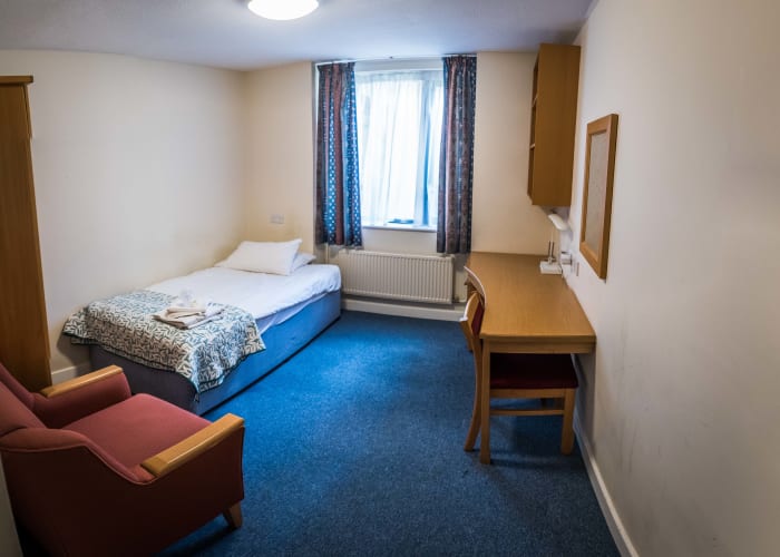 Single En-Suite Bedroom with bed, lounge chair and desk. Great conference accommodation.