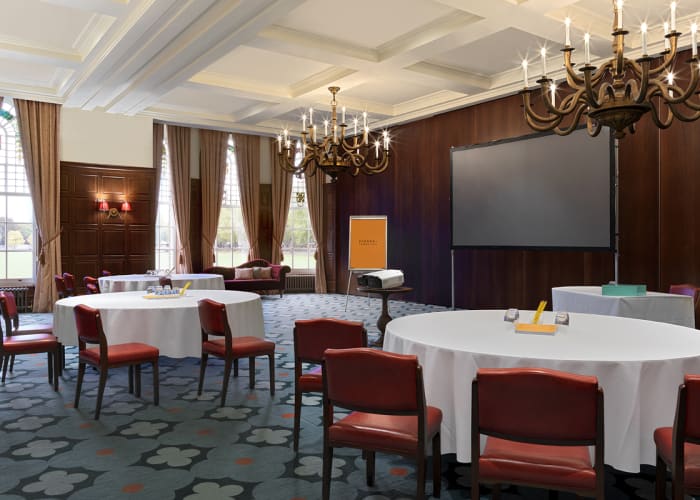 A beautiful meeting room with chandeliers and paned windows overlooking Parker's Piece.