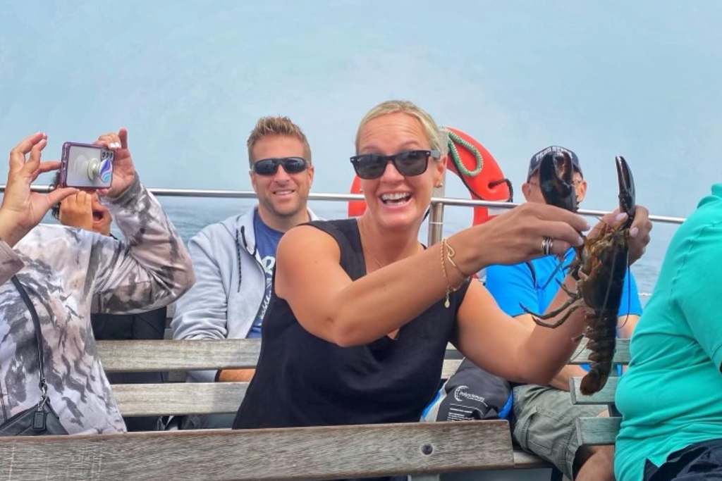 Girl with Lobster on Boat. Photo Credit: Experience Maine