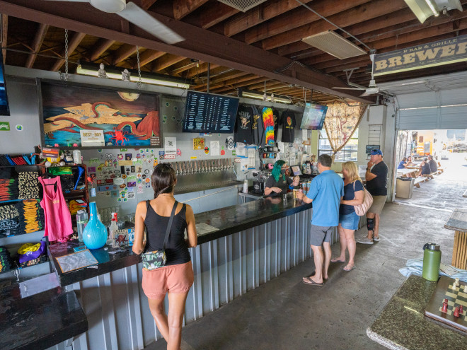 People ordering drinks at the bar at Cage Brewing