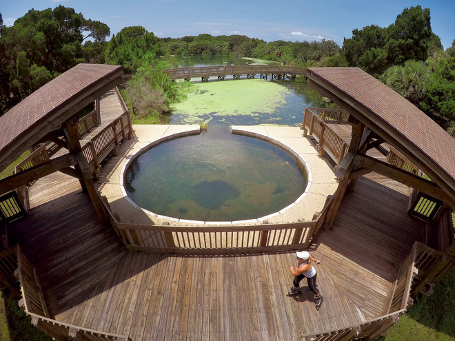 woman walking on the boardwalk over the natural spring