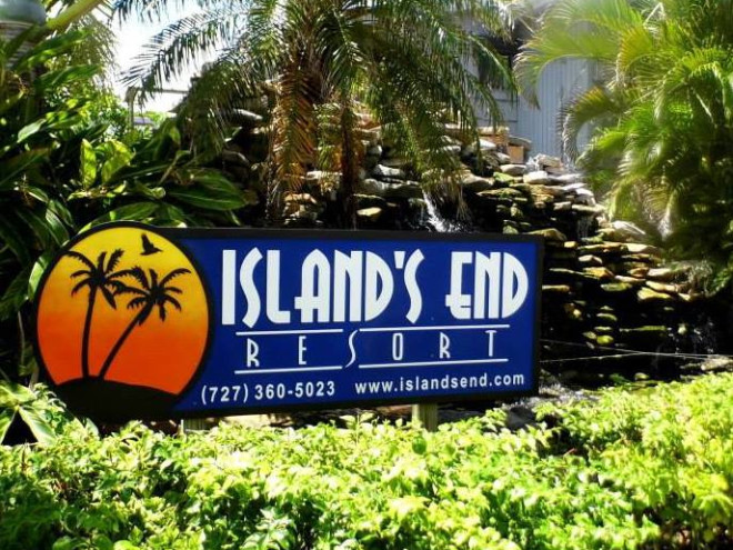 Island's End Resort entrance with waterfall and palm trees