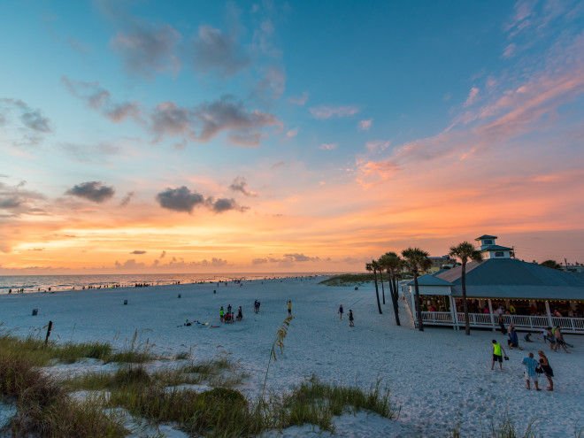 People on the beach outside of Palm Pavilion Beachside Grill & Bar Exterior