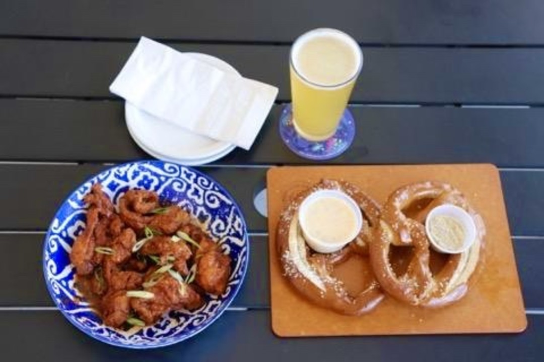 Pretzels, wings, and drinks served on a patio table at Low Tide Bar and Grill in Corolla